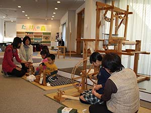 糸つむぎや綿繰りを体験する子どもたち